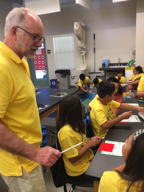 A BASIC teacher leading a lesson with Reading Academy students seated at classroom tables