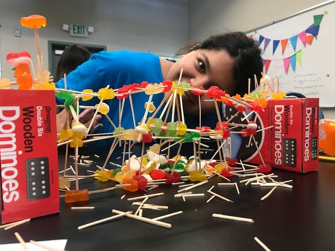 A Learning Academy student building a candy-and-toothpick structure