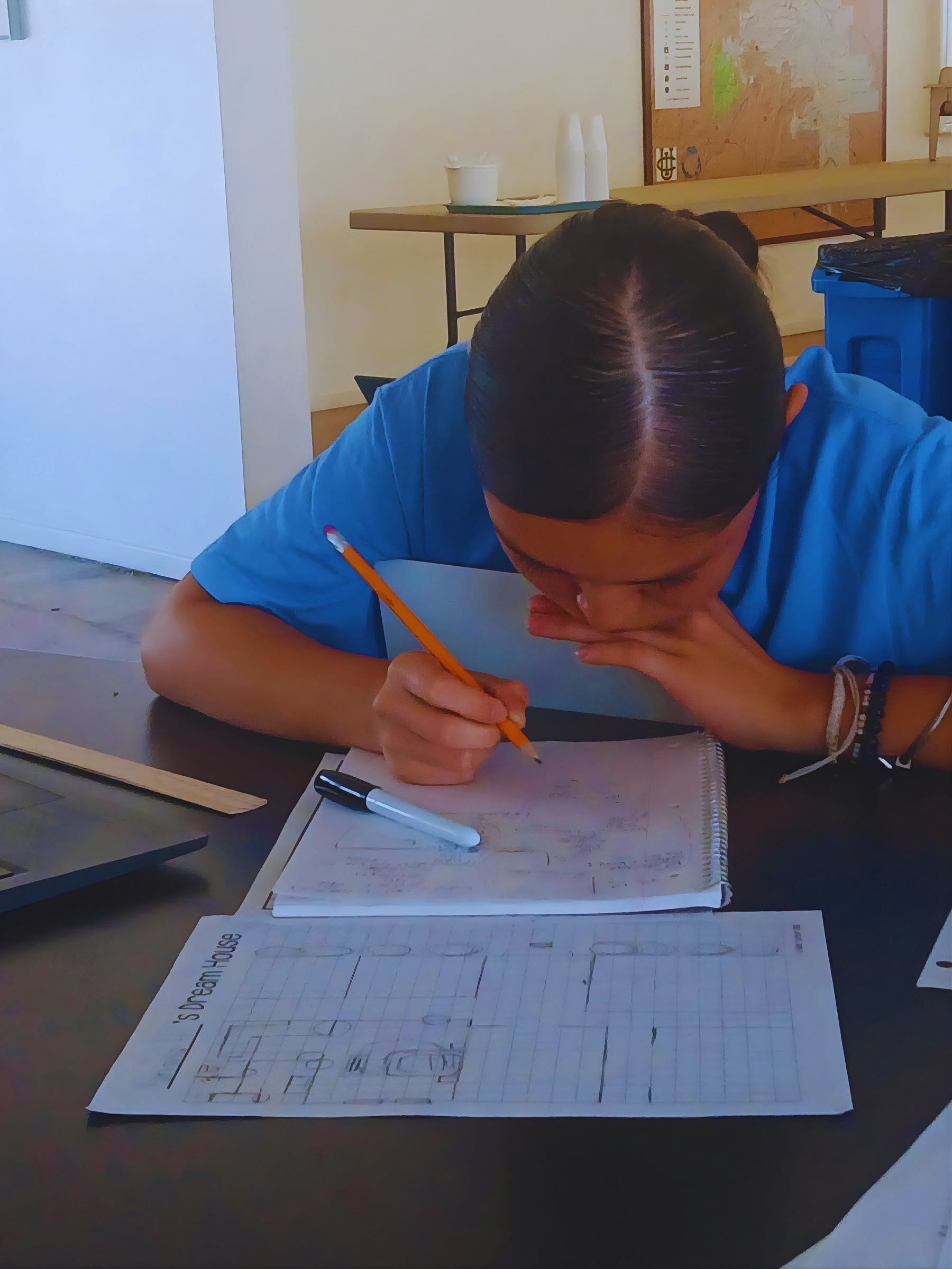A Learning Academy student working carefully through a grid worksheet