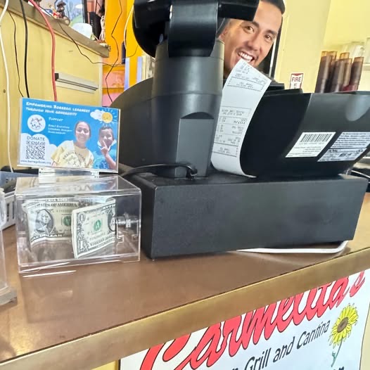 The BASIC donation box beside the register at Carmelita's, with a few dollar bills inside