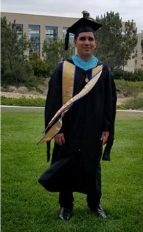 Jesus Arias in cap and gown at his graduation ceremony
